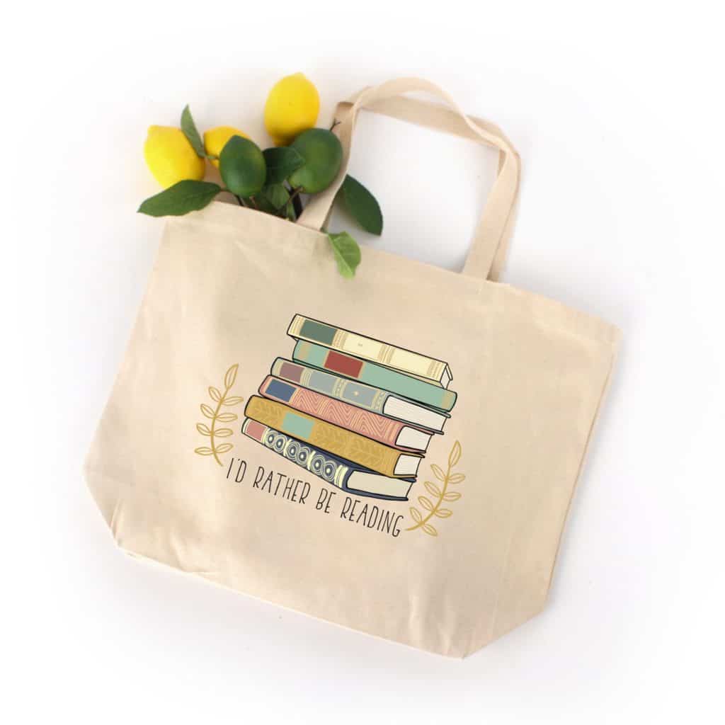 canvas tote bag with illustrated stack of books that says i'd rather be reading