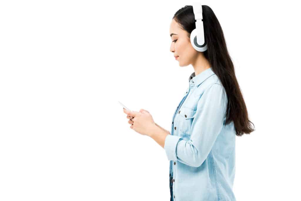 girl listening to headphones with phone in hand