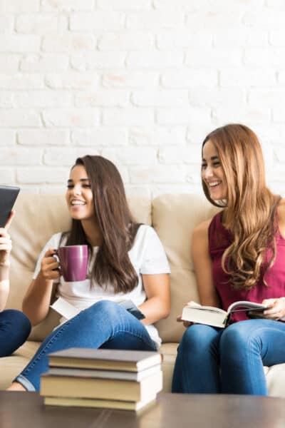 Cute young woman reading a quote from a book while attending a book club reunion