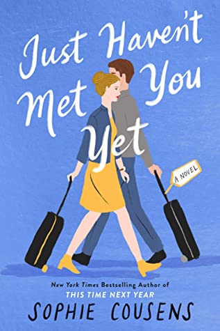 Book cover for Just Haven't Met You Yet -- book cover is a periwinkle color. A woman and man (illustrated) are crossing one another, going opposite ways, holding black rolling suitcases ebhind them.